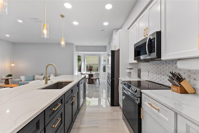 kitchen featuring sink, light stone countertops, decorative light fixtures, white cabinetry, and stainless steel appliances