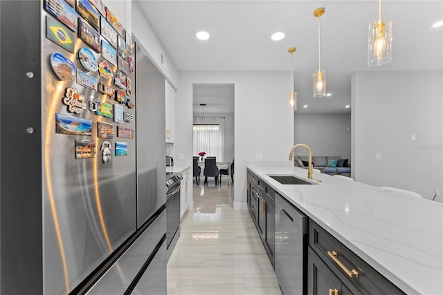 kitchen featuring light stone countertops, stainless steel appliances, sink, decorative light fixtures, and white cabinets