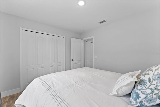 bedroom featuring wood-type flooring and a closet