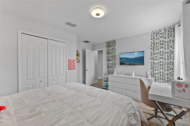 bedroom with light hardwood / wood-style flooring and a closet