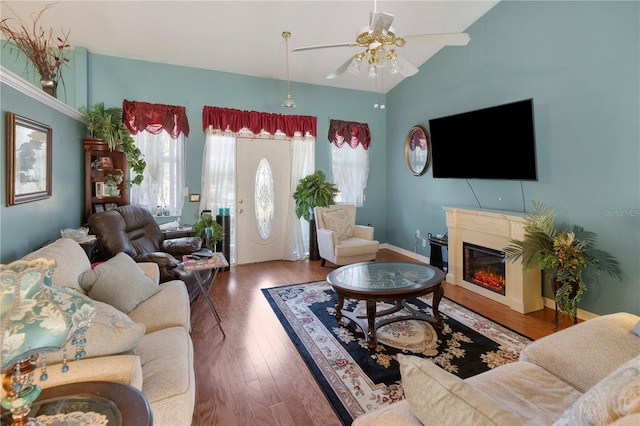 living room featuring hardwood / wood-style flooring, vaulted ceiling, and ceiling fan