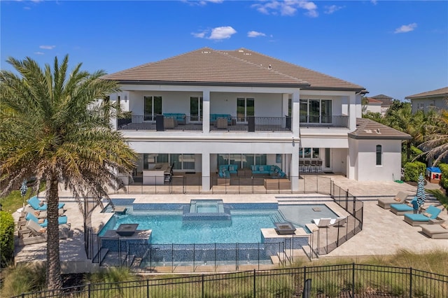 back of house featuring an outdoor living space, a balcony, a patio, and a pool with hot tub