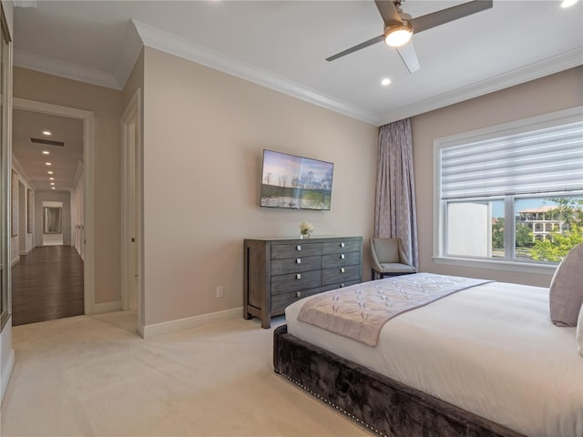 carpeted bedroom with ceiling fan and ornamental molding