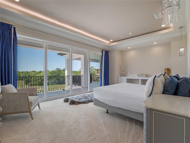 carpeted bedroom with access to outside and a raised ceiling