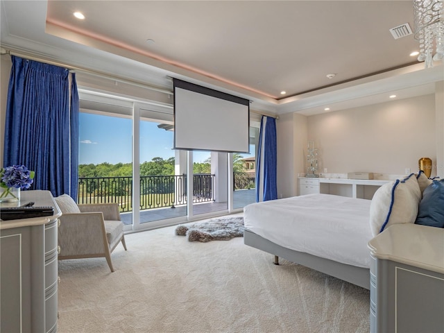 bedroom featuring a tray ceiling, access to exterior, and light colored carpet