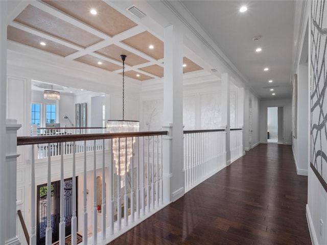 hall featuring coffered ceiling, crown molding, beamed ceiling, a chandelier, and hardwood / wood-style floors