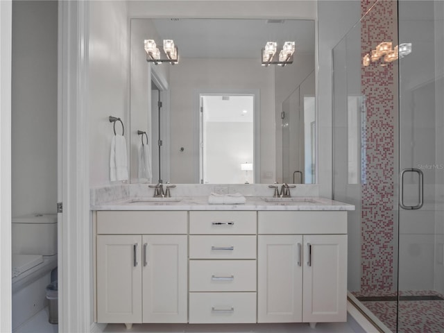 bathroom featuring vanity, a chandelier, an enclosed shower, and toilet