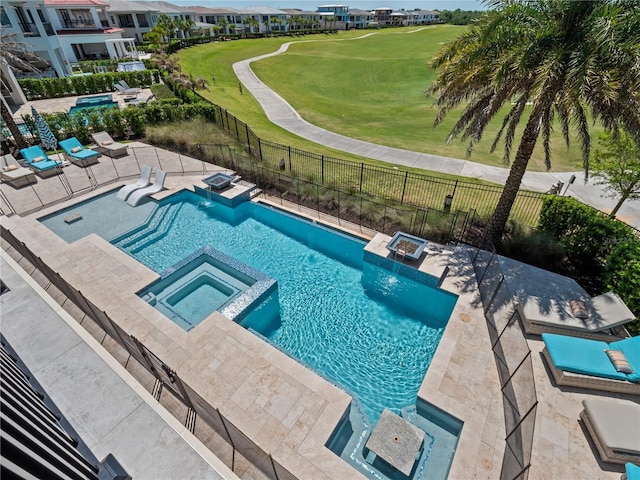 view of swimming pool featuring a lawn, a patio area, and an in ground hot tub