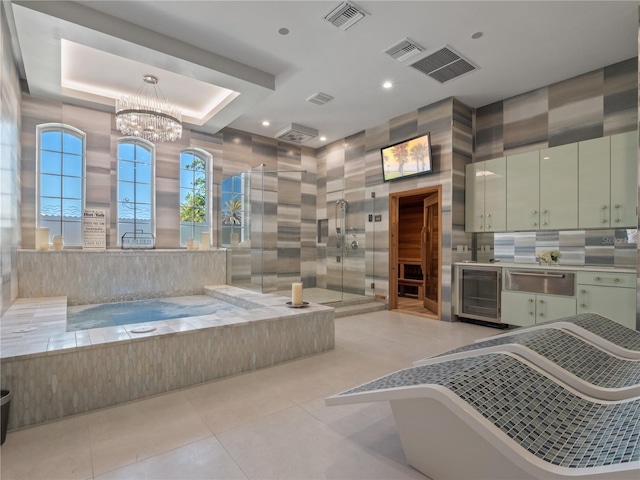 interior space featuring an inviting chandelier, tile patterned floors, a raised ceiling, wine cooler, and a shower with shower door