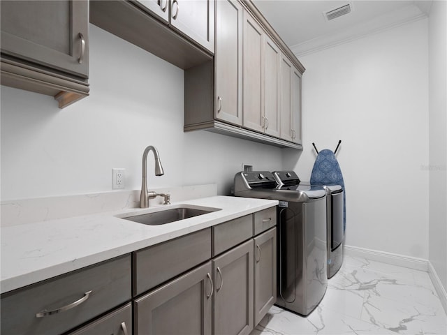 laundry room featuring cabinets, separate washer and dryer, sink, and ornamental molding