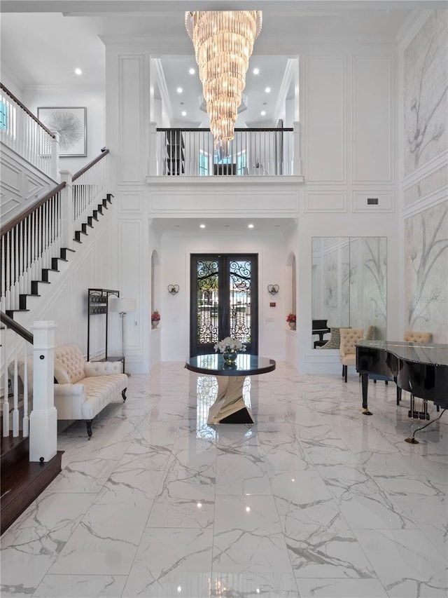 entryway featuring a high ceiling, an inviting chandelier, and french doors