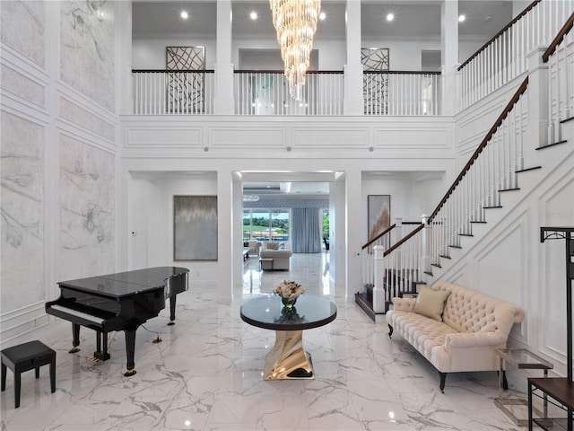 foyer with a high ceiling, crown molding, and a notable chandelier