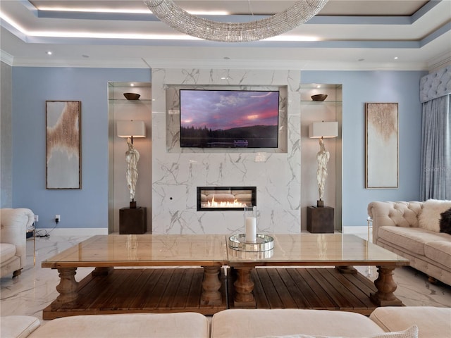 living room featuring ornamental molding, a high end fireplace, and a tray ceiling