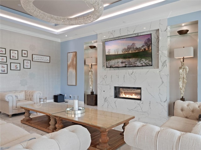 living room featuring a fireplace, a tray ceiling, and ornamental molding