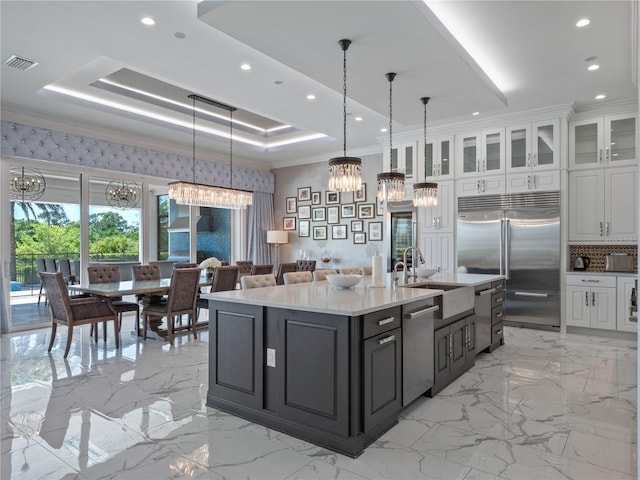 kitchen featuring white cabinets, crown molding, a raised ceiling, and stainless steel appliances