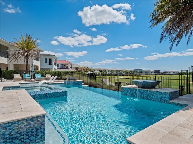 view of pool featuring pool water feature and an in ground hot tub