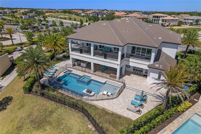 back of property with a balcony, a fenced in pool, and a patio area