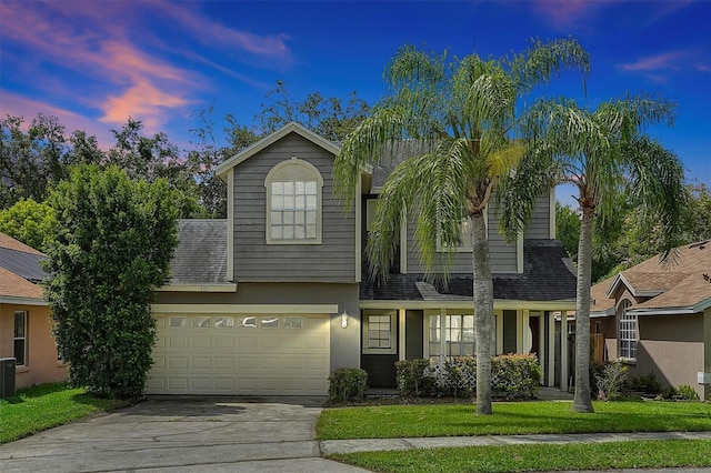 view of front of home featuring a yard, cooling unit, and a garage