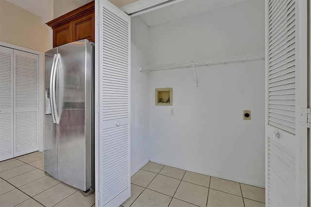 washroom with hookup for an electric dryer, light tile patterned floors, and washer hookup