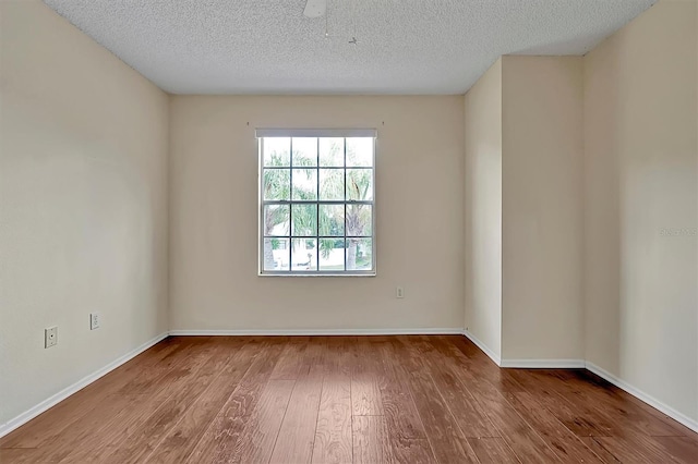 spare room with a textured ceiling and hardwood / wood-style flooring