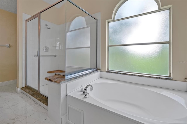 bathroom featuring separate shower and tub, a healthy amount of sunlight, and a textured ceiling