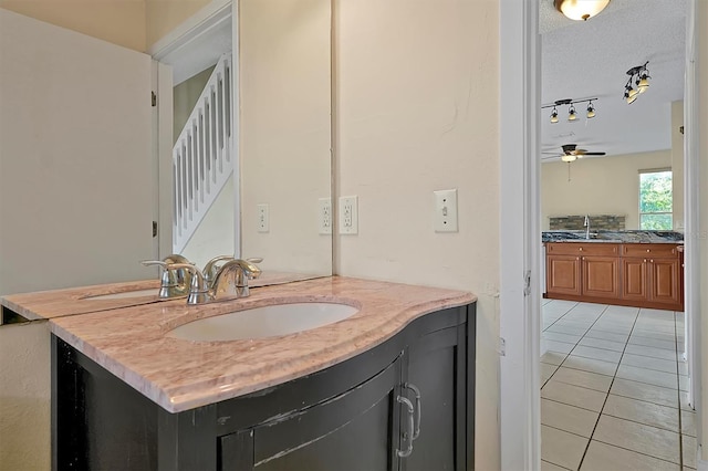 bathroom with tile patterned flooring, vanity, a textured ceiling, and ceiling fan