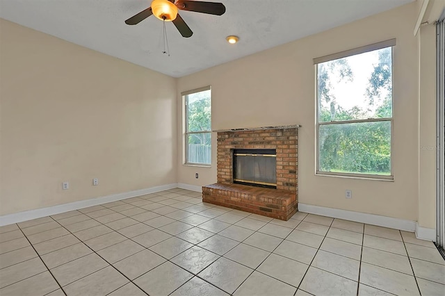 unfurnished living room featuring ceiling fan, light tile patterned flooring, and a brick fireplace