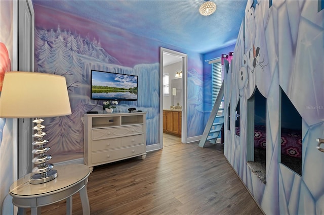 bedroom featuring hardwood / wood-style floors, a textured ceiling, and connected bathroom