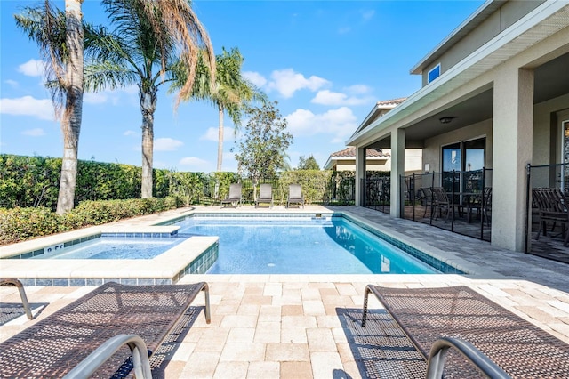 view of pool with a patio area and an in ground hot tub