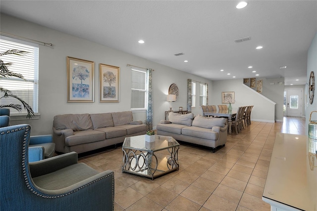 living room featuring plenty of natural light, light tile patterned flooring, and a textured ceiling