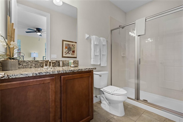 bathroom featuring vanity, tile patterned flooring, ceiling fan, toilet, and a shower with shower door