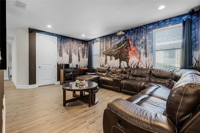 living room with light wood-type flooring and a textured ceiling