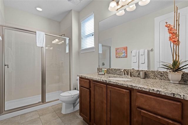 bathroom featuring tile patterned flooring, a shower with door, vanity, and toilet