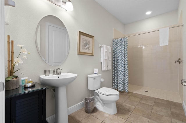 bathroom with tile patterned floors, toilet, curtained shower, and sink