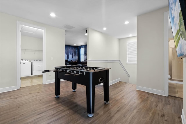 playroom featuring independent washer and dryer and hardwood / wood-style floors