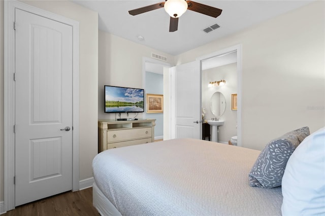 bedroom with ceiling fan, dark hardwood / wood-style floors, and connected bathroom