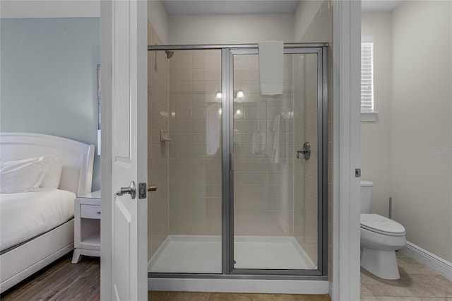 bathroom with a shower with door and toilet