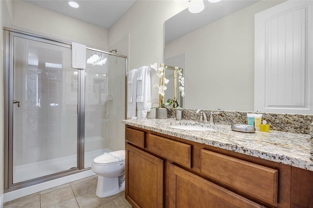 bathroom featuring tile patterned floors, vanity, an enclosed shower, and toilet