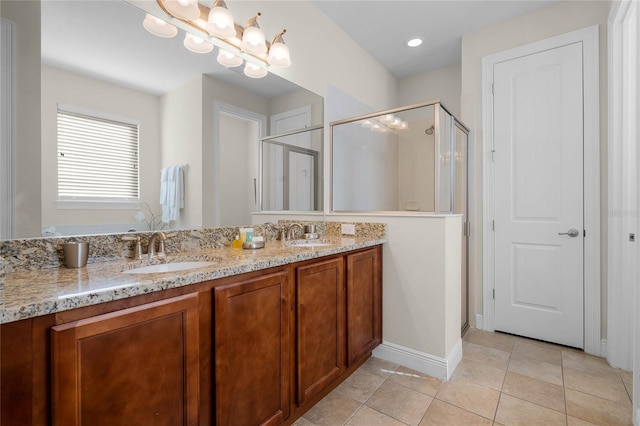 bathroom featuring tile patterned flooring, vanity, a chandelier, and walk in shower