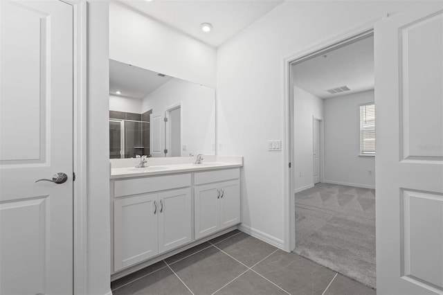 bathroom with an enclosed shower, vanity, and tile patterned floors