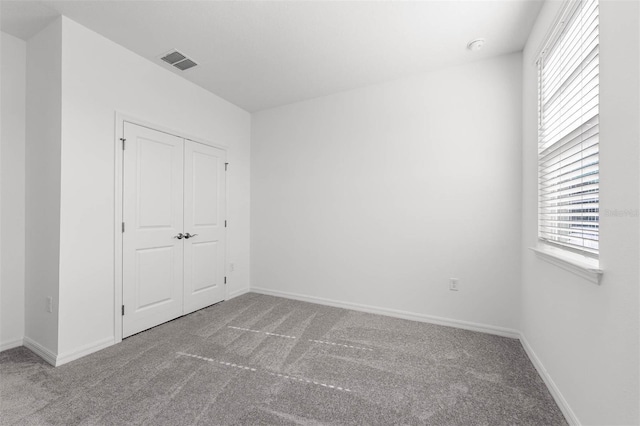 unfurnished bedroom featuring carpet floors and a closet