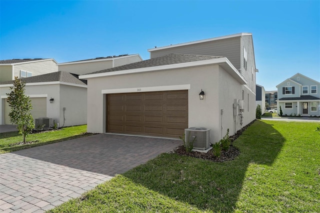 view of side of property with central AC, a yard, and a garage