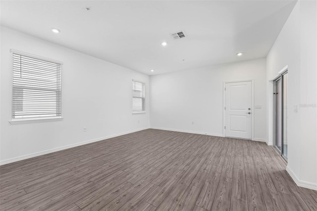 unfurnished room featuring dark hardwood / wood-style flooring and a wealth of natural light