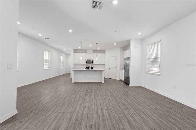 unfurnished living room featuring wood-type flooring and plenty of natural light