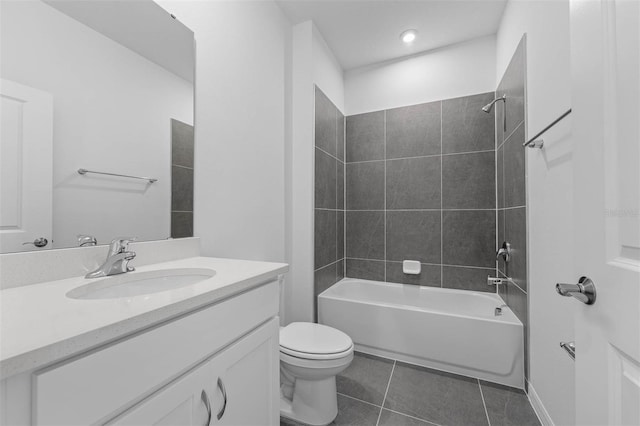 full bathroom with tile patterned flooring, vanity, tiled shower / bath combo, and toilet