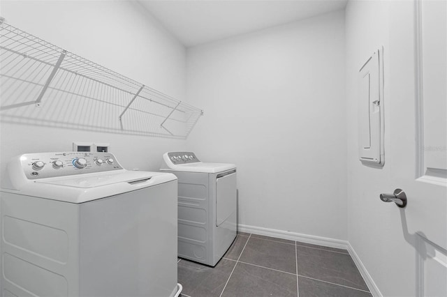 clothes washing area featuring dark tile patterned floors and washing machine and clothes dryer