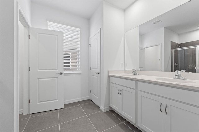 bathroom with tile patterned flooring, vanity, and walk in shower