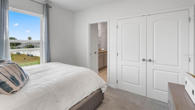 carpeted bedroom featuring ensuite bath and a closet