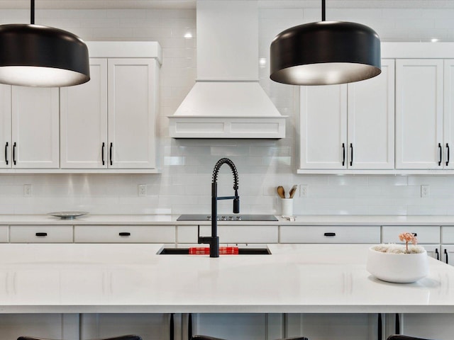 kitchen featuring white cabinetry, exhaust hood, and tasteful backsplash