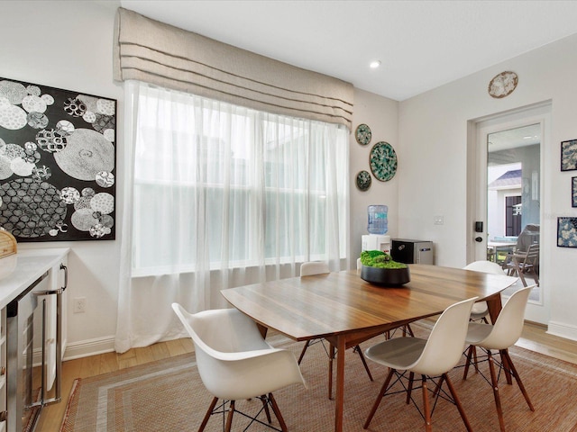 dining room with wine cooler and light hardwood / wood-style flooring